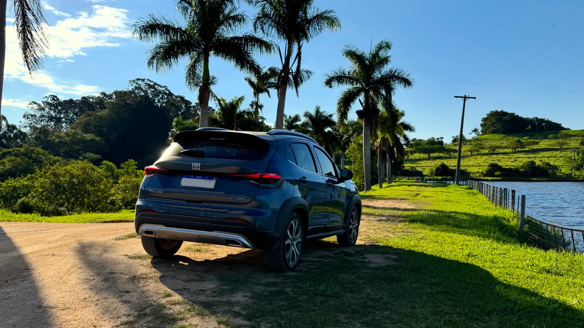 Fiat Pulse híbrido azul visto da traseira em uma fazenda